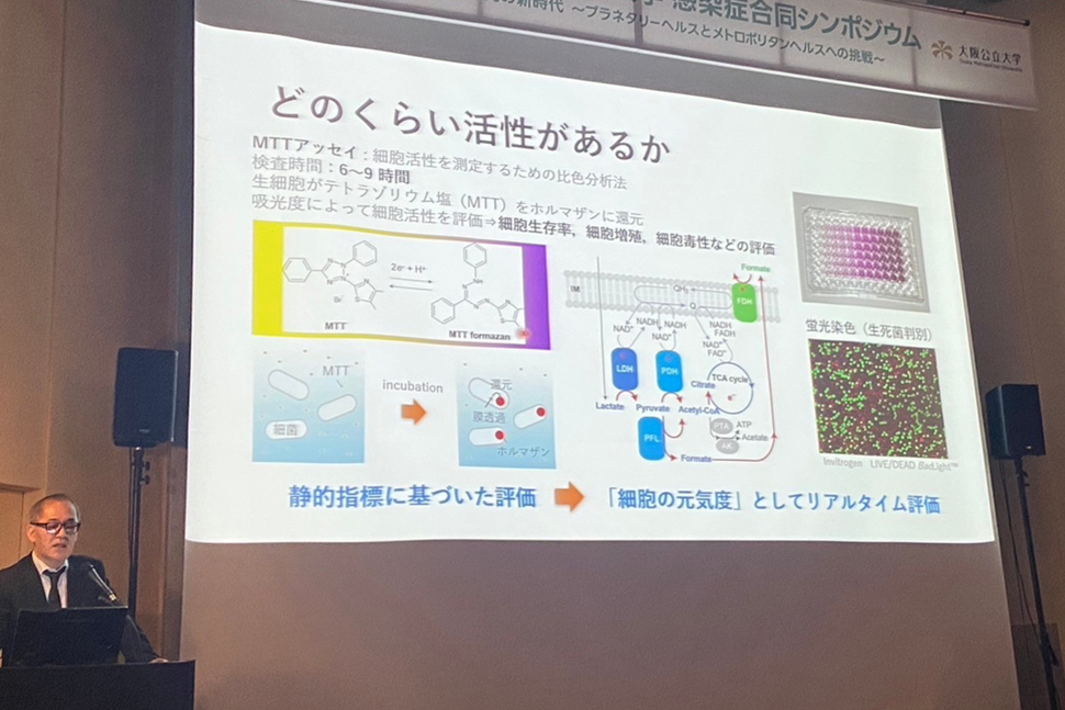 写真：登壇者と発表スライド